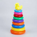Colorful stacking rings toy with a yellow rubber duck on top against a white background